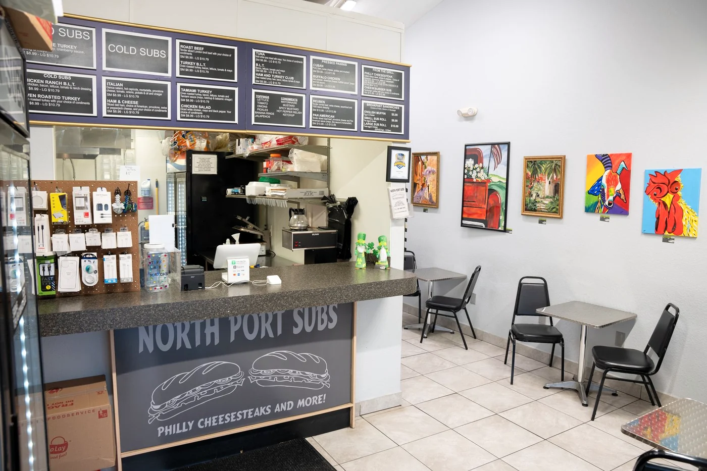 North Port Subs counter and seating with colorful artwork on the walls